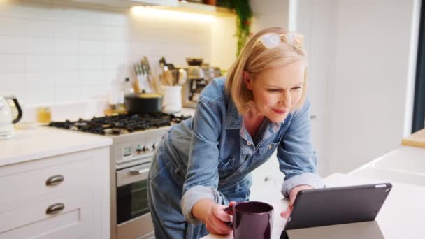 Olgun Bir Kadın Mutfakta Kahve Içiyor Yavaş Çekimde Dijital Tablete — Stok video