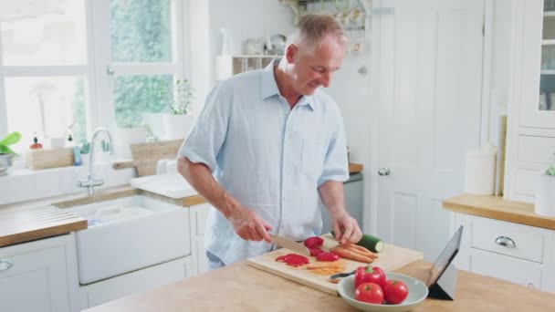 Pensionerad Äldre Man Hugga Grönsaker För Måltid Köket Enligt Recept — Stockvideo