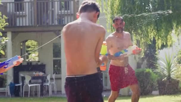 Family Wearing Swimming Costumes Having Water Fight Filling Water Pistols — Stock Video