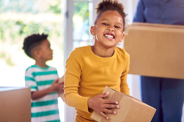 母が移動中に新しい家に箱を運ぶのを助ける子供たち — ストック写真