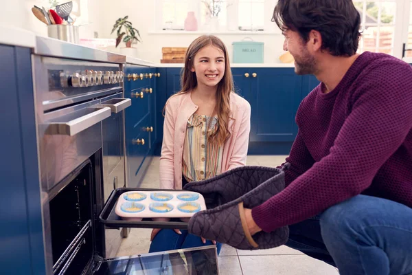 Vater Mit Teenager Tochter Putting Hausgemachte Cupcakes Ofen Backen — Stockfoto