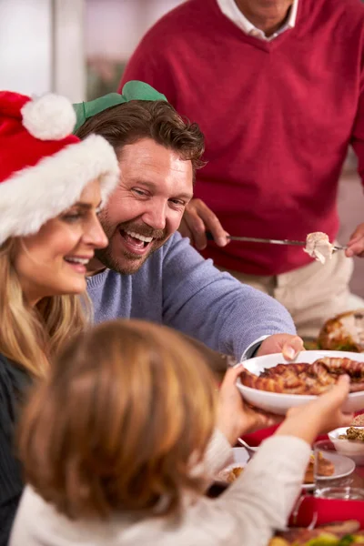 Familia Multi Generación Sombreros Santa Disfrutando Comer Comida Navideña Casa — Foto de Stock