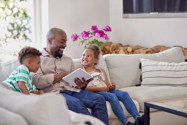 Padre Seduto Sul Divano Con Bambini Casa Lettura Libro Insieme — Foto Stock