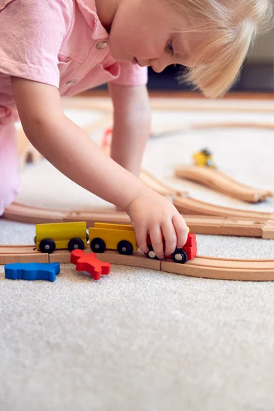 Evde Tahta Tren Setiyle Oynayan Genç Bir Kız Halıda Oyuncak — Stok fotoğraf