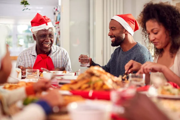 Mehrgenerationenfamilie Papierhüten Genießt Gemeinsam Das Weihnachtsessen Hause — Stockfoto