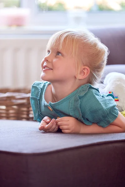Χαμογελώντας Νεαρή Κοπέλα Κάθεται Στον Καναπέ Στο Σαλόνι Στο Σπίτι — Φωτογραφία Αρχείου