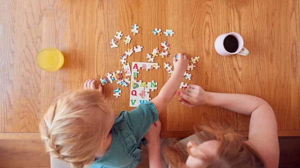 Overhead Shot Mother Daughter Sitting Table Home Doing Jigsaw Puzzle —  Fotos de Stock