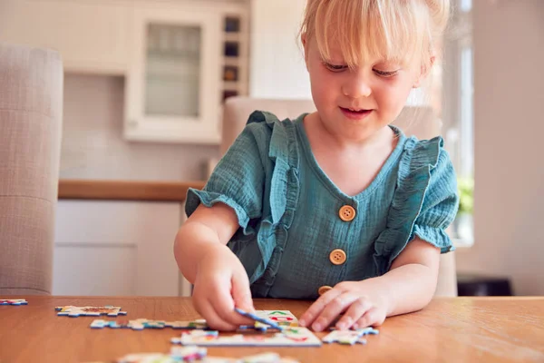 Giovane Ragazza Diverte Seduto Tavola Casa Facendo Puzzle — Foto Stock