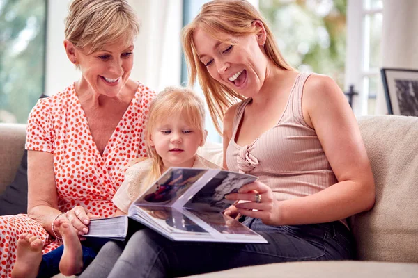 Grandmother Sitting Sofa Adult Daughter Granddaughter Home Looking Photo Album — Stock Photo, Image