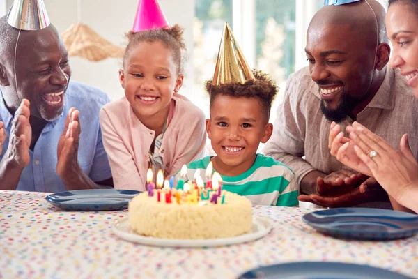 多代家庭围坐在桌旁 用蛋糕和派对庆祝男孩的生日 — 图库照片