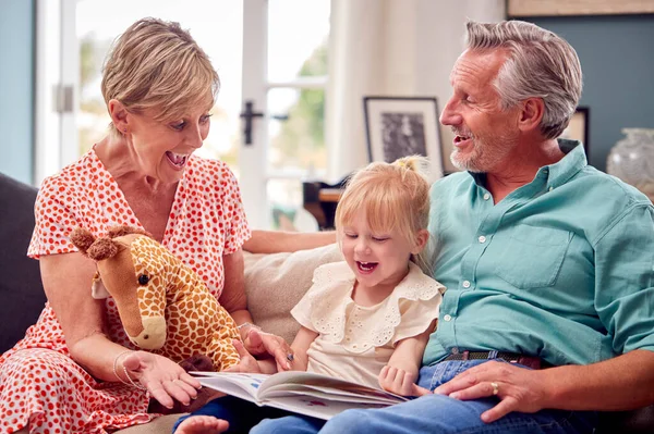 Abuelos Sentados Sofá Con Nieta Casa Lectura Libro Juntos — Foto de Stock