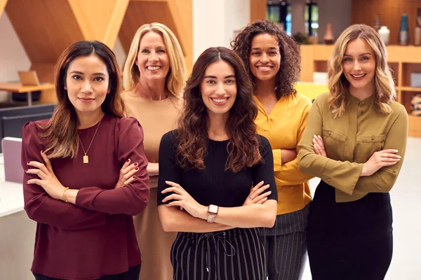 Portrait Of Multi-Cultural Female Business Team Standing In Modern Open Plan Office