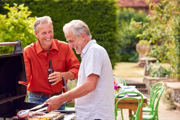 Twee Senior Mannelijke Vrienden Koken Outdoor Barbecue Drinken Bier Thuis — Stockfoto
