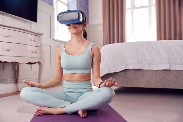 Vrouw Draagt Virtual Reality Headset Zittend Yoga Mat Slaapkamer Thuis — Stockfoto