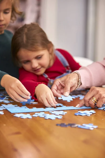 Close Dei Nipoti Con Nonni Seduti Tavola Casa Fare Puzzle — Foto Stock