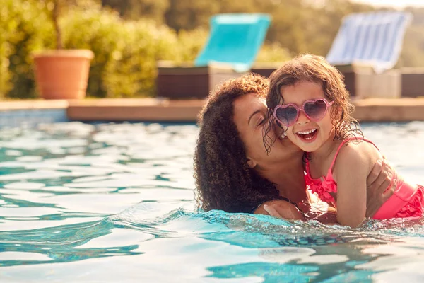 放声大笑妈妈和女儿带着太阳镜在游泳池里玩乐放暑假 — 图库照片