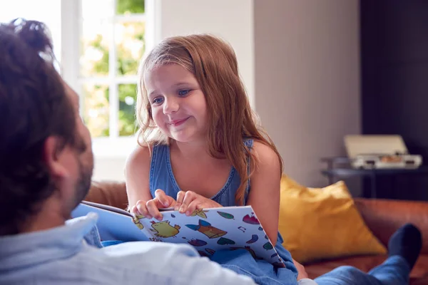 Father Daughter Lying Sofa Home Girl Reads Book — Stock Photo, Image