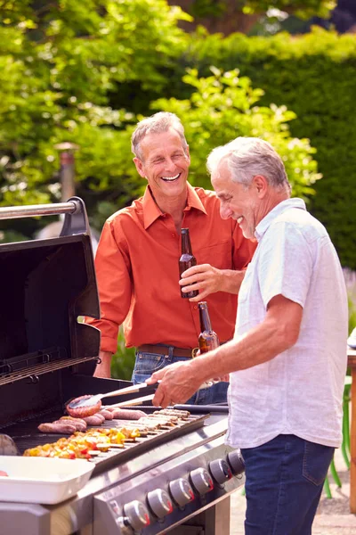 两位资深男性朋友一起烹调户外烧烤和在家喝啤酒 — 图库照片