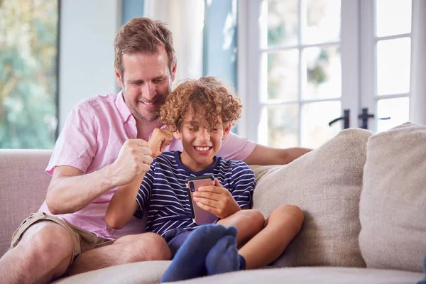 Padre Hijo Sentados Sofá Casa Jugando Teléfono Móvil Juntos — Foto de Stock