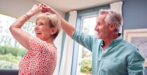 ロマンチックなシニア退職したカップルが一緒に自宅でラウンジで踊る — ストック写真