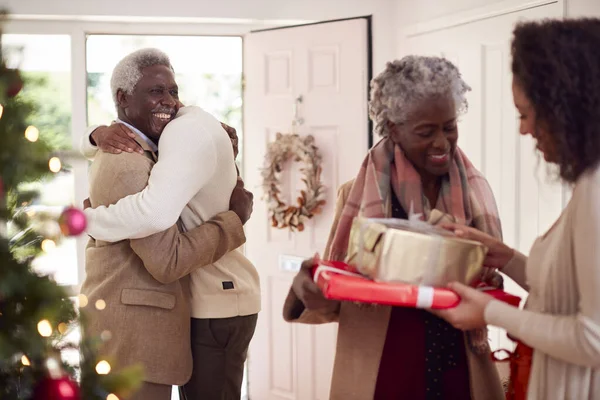 Volwassen Kinderen Begroeten Oudere Ouders Als Aankomen Met Cadeautjes Kerstmis — Stockfoto