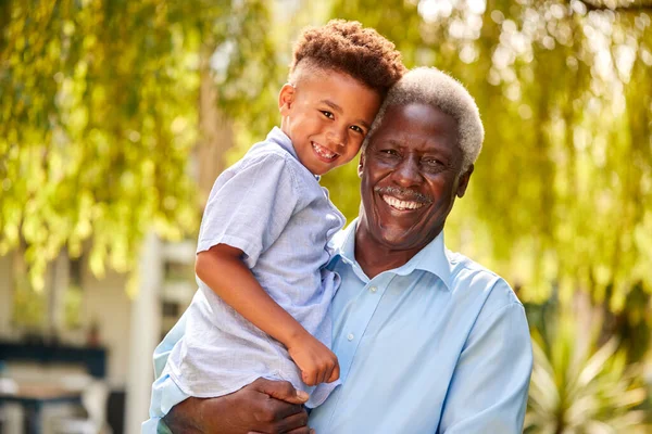 Portret Kochającego Dziadka Trzymającego Wnuka Ramionach Ogrodzie Domu — Zdjęcie stockowe
