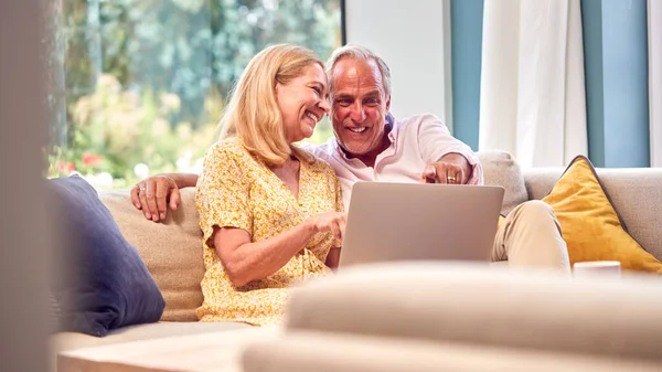 Senior Retired Couple Sitting Sofa Home Shopping Booking Holiday Laptop — Stock Photo, Image