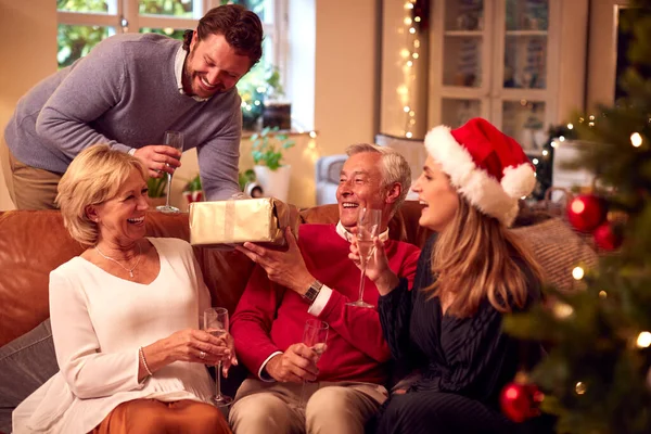 Pareja Dando Regalos Los Padres Mayores Mientras Celebran Navidad Casa —  Fotos de Stock