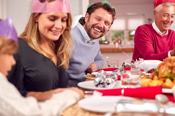 Семья Нескольких Поколений Санта Шляпах Наслаждается Рождественской Едой Дома Вместе — стоковое фото