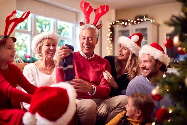 多世代家族の交流と自宅でクリスマスツリーの周りの贈り物を開く — ストック写真