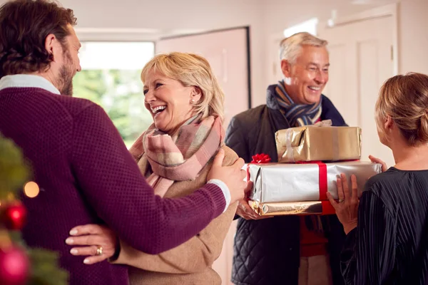 Paar Groet Senior Ouders Als Aankomen Met Cadeautjes Kerstmis Vieren — Stockfoto