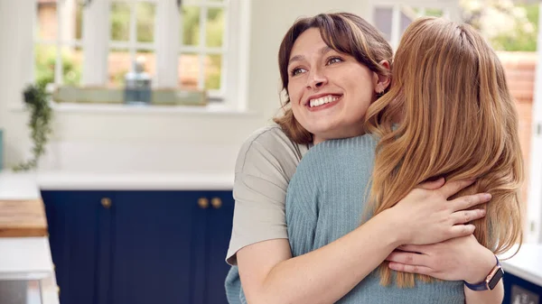 Duas Amigas Cumprimentando Abraçando Cozinha Casa — Fotografia de Stock