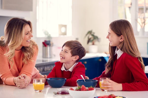 Madre Having Colazione Con Bambini Scuola Uniforme Cucina Contatore — Foto Stock