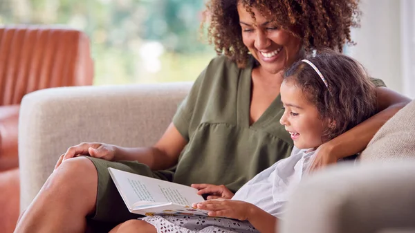 Mother Daughter Sitting Sofa Home Reading Book Together — Stock Photo, Image