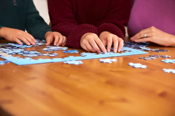 Close Family Sitting Table Home Doing Jigsaw Puzzle Together — Stock Photo, Image