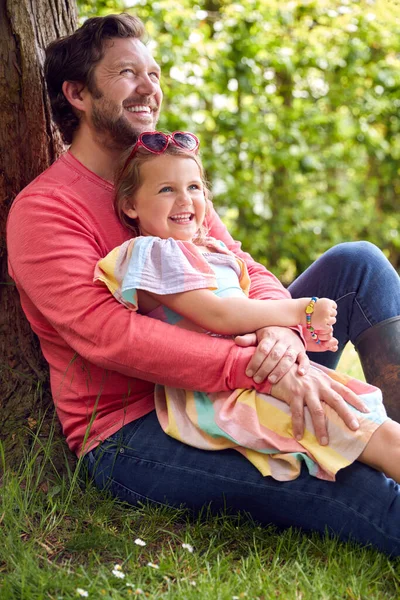 Loving Father Cuddling Young Daughter Sitting Tree Garden Together — Stock Photo, Image