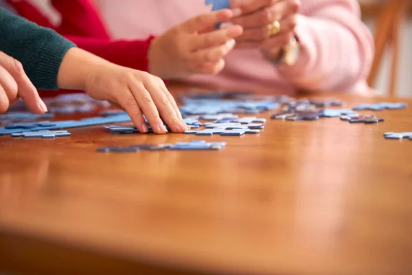 Zbliżenie Wnuki Dziadkami Siedzieć Przy Stole Domu Robi Puzzle Razem — Zdjęcie stockowe