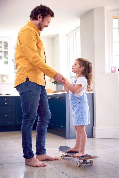 Padre Ayudando Hija Equilibrarse Monopatín Interior Casa — Foto de Stock