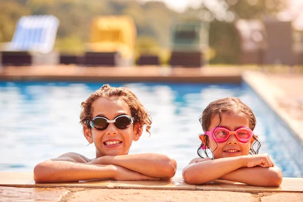 暑假时 男孩和女孩靠在游泳池边的肖像 — 图库照片