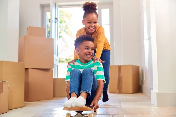 Due Bambini Con Scatole Che Muovono Giorno Giocando Sullo Skateboard — Foto Stock