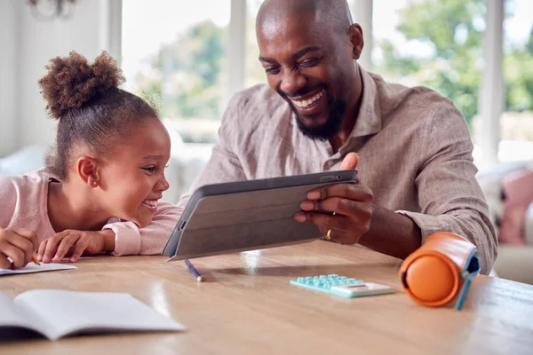 Far Hjälper Dotter Med Hemundervisning Sitter Vid Bordet Med Digital — Stockfoto