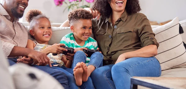 Padres Sentados Sofá Con Niños Casa Jugando Videojuegos Juntos —  Fotos de Stock