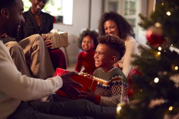 多代家庭在家中交换和开放圣诞树周围的礼物 — 图库照片