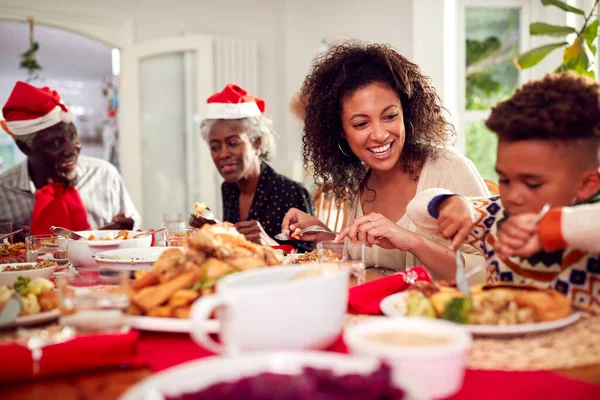 Multi Generation Family Paper Hats Enjoying Eating Christmas Meal Home — Stock Photo, Image