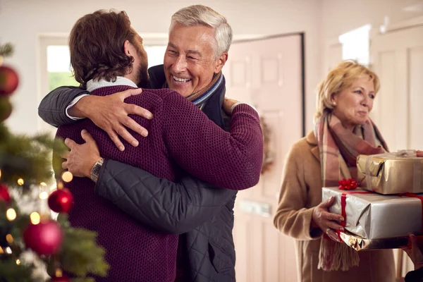 Pareja Saludando Padres Mayores Mientras Llegan Con Regalos Para Celebrar — Foto de Stock