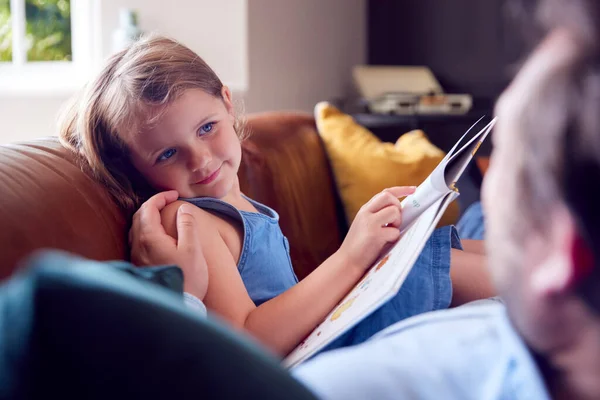 Far Och Dotter Ligger Soffan Hemma Som Flicka Läser Bok — Stockfoto