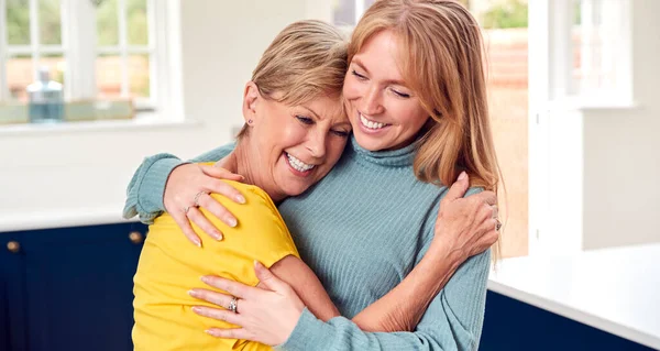 Seniorin Grüßt Und Umarmt Erwachsene Tochter Hause — Stockfoto