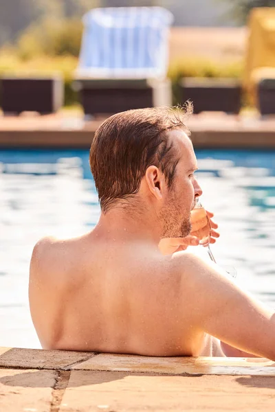 男子度假游泳池放松饮茶的后视镜 — 图库照片