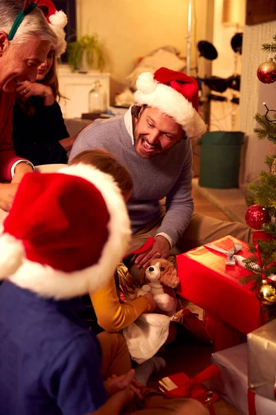 多世代家族の交流と自宅でクリスマスツリーの周りの贈り物を開く — ストック写真