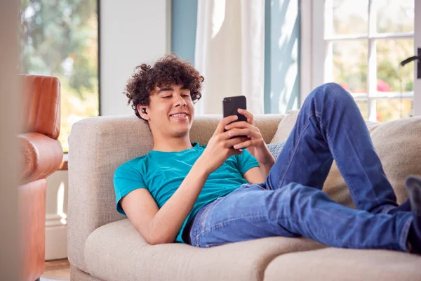 Мальчик Подросток Лежит Диване Дома Помощью Мобильного Телефона — стоковое фото
